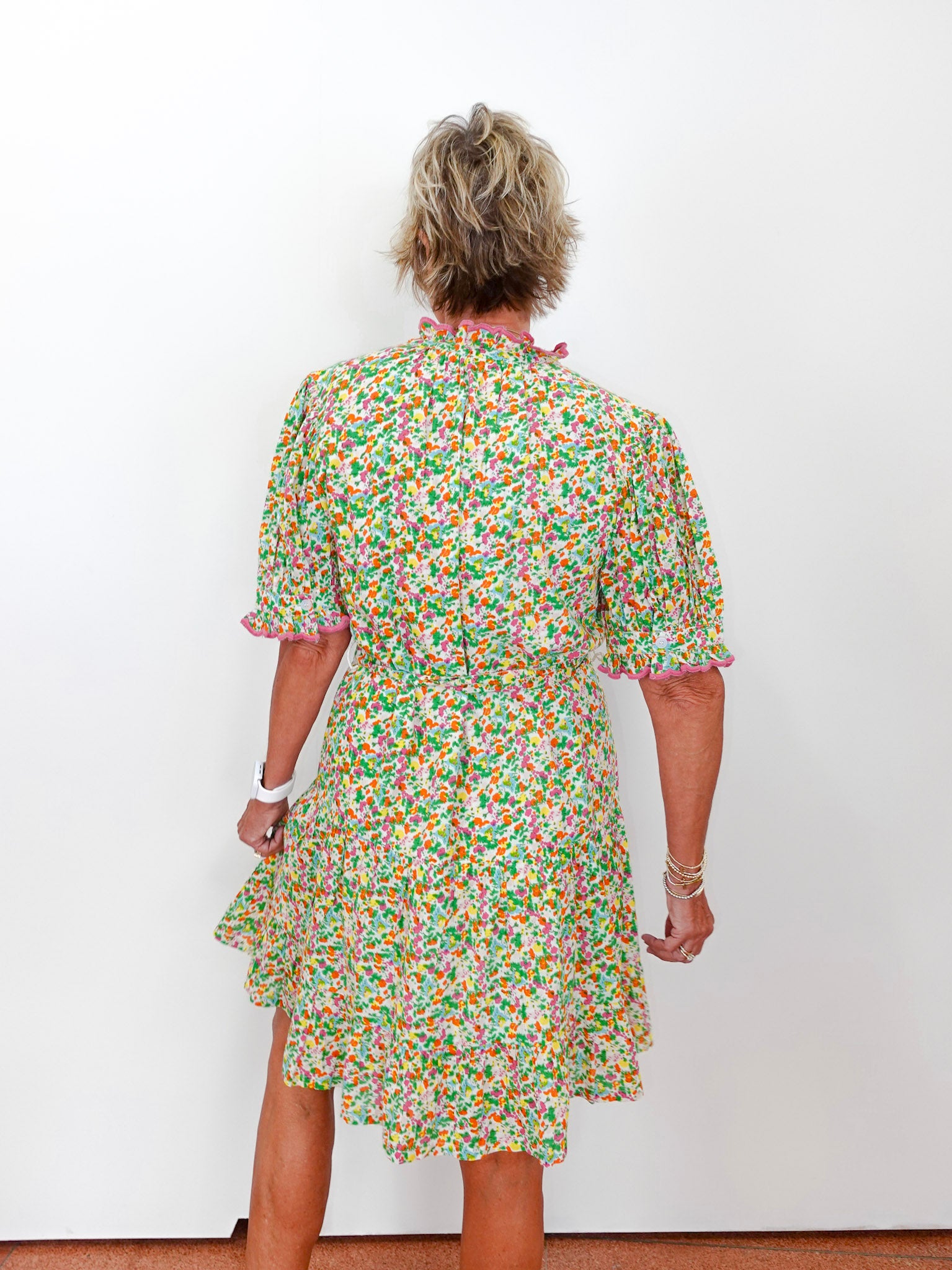 Person wearing a floral dress against a white background