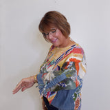 Woman wearing a colorful patterned sweater against a white wall