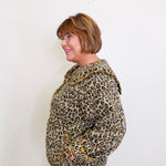 Person wearing a leopard print jacket against a white background