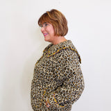Person wearing a leopard print jacket against a white background