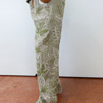 Person wearing green floral pants on a plain background