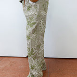 Person wearing green floral pants on a plain background
