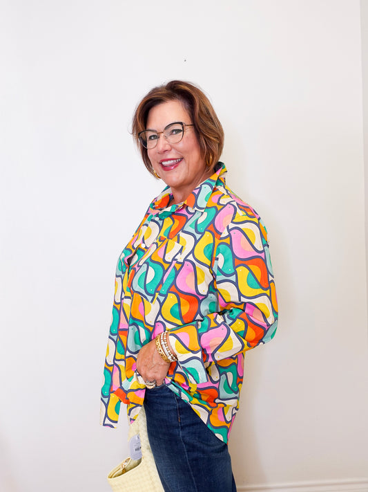 Woman wearing a colorful patterned shirt against a white background
