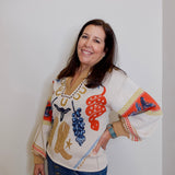 Woman wearing a colorful sweater with patterns on a white background