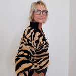 Person wearing a tiger-striped sweater against a plain background