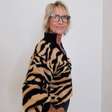Person wearing a tiger-striped sweater against a plain background