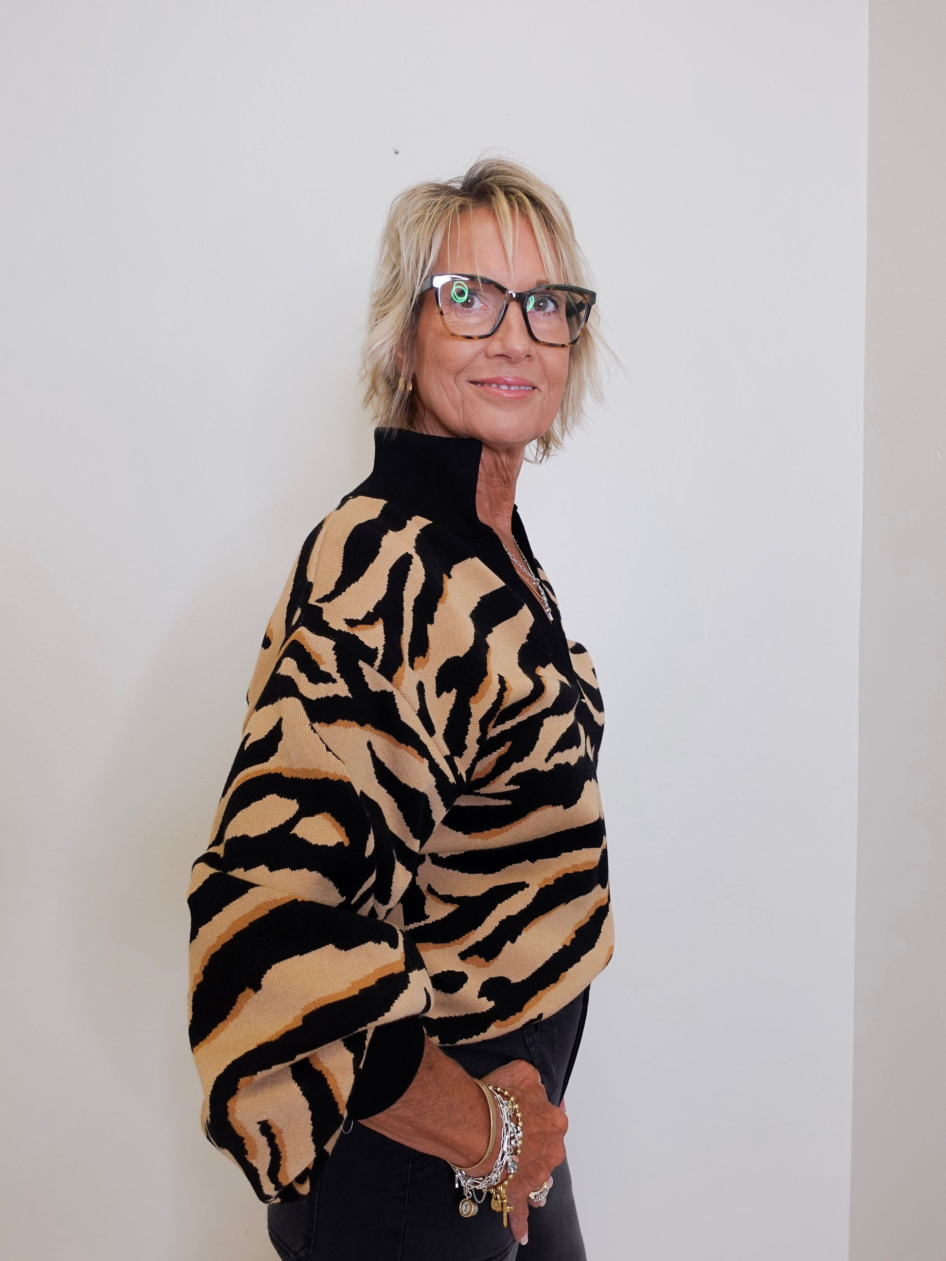 Person wearing a tiger-striped sweater against a plain background