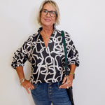 woman wearing a black and white long sleeve top from Emily McCarthy. 