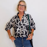 woman wearing a black and white long sleeve top from Emily McCarthy. 