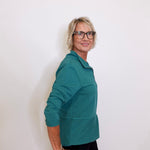 Person wearing a teal jacket against a white background