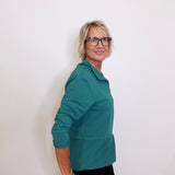 Person wearing a teal jacket against a white background