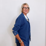 Person wearing a blue denim jacket against a white background