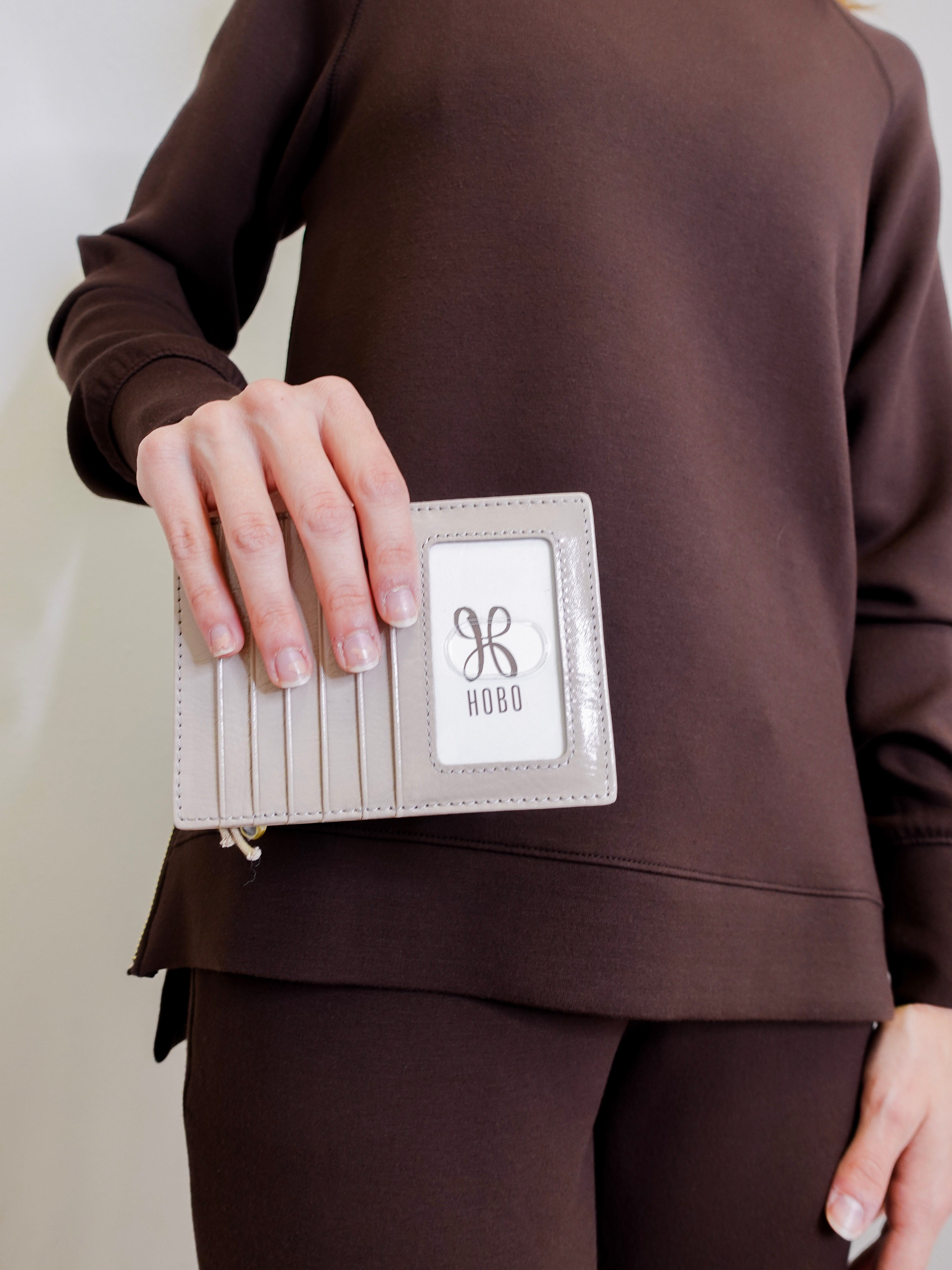 woman holding Beige passport holder with a zipper containing an Australian passport on a white background
