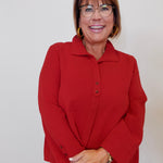 Woman wearing a red jacket against a plain background