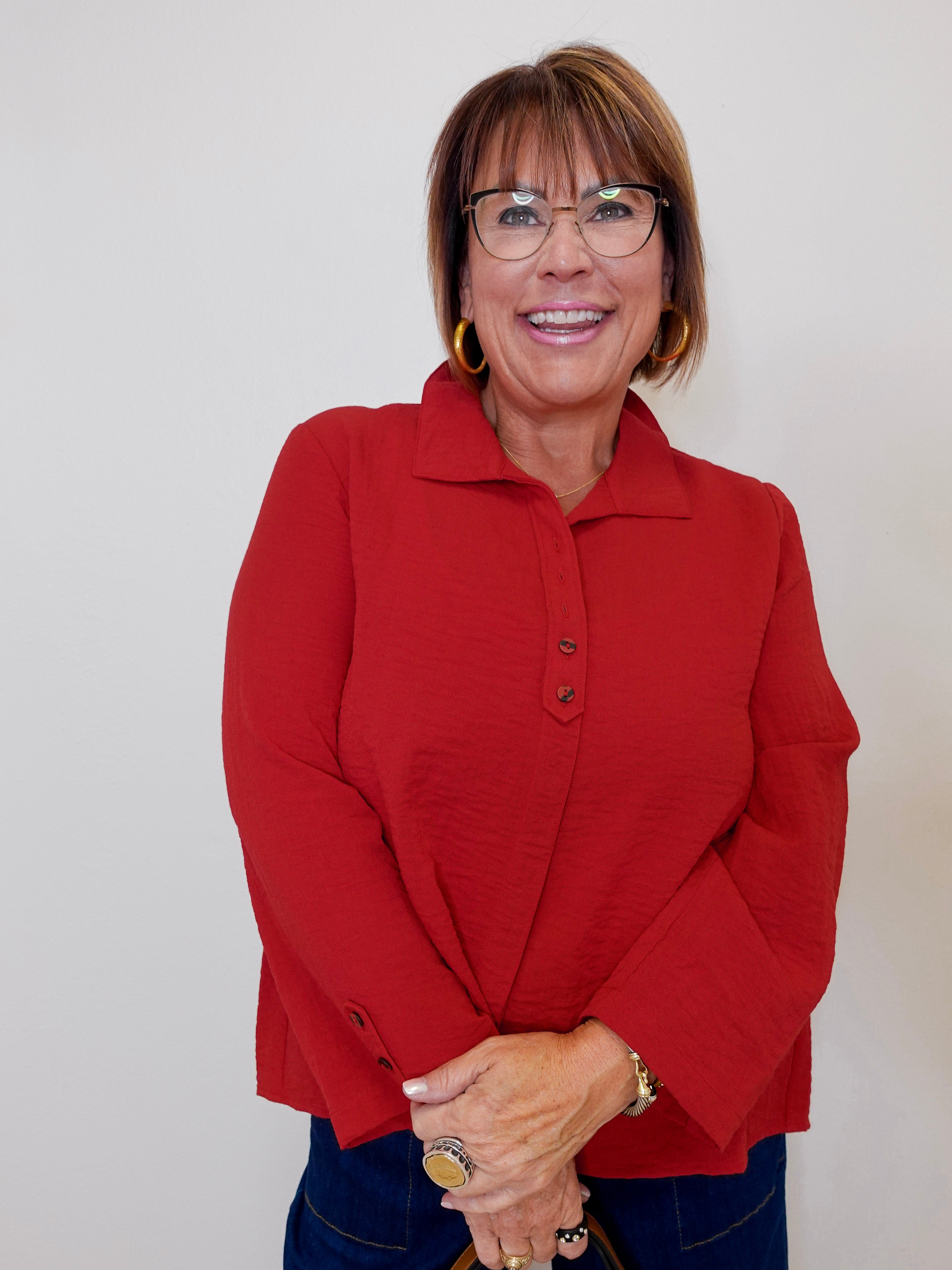 Woman wearing a red jacket against a plain background