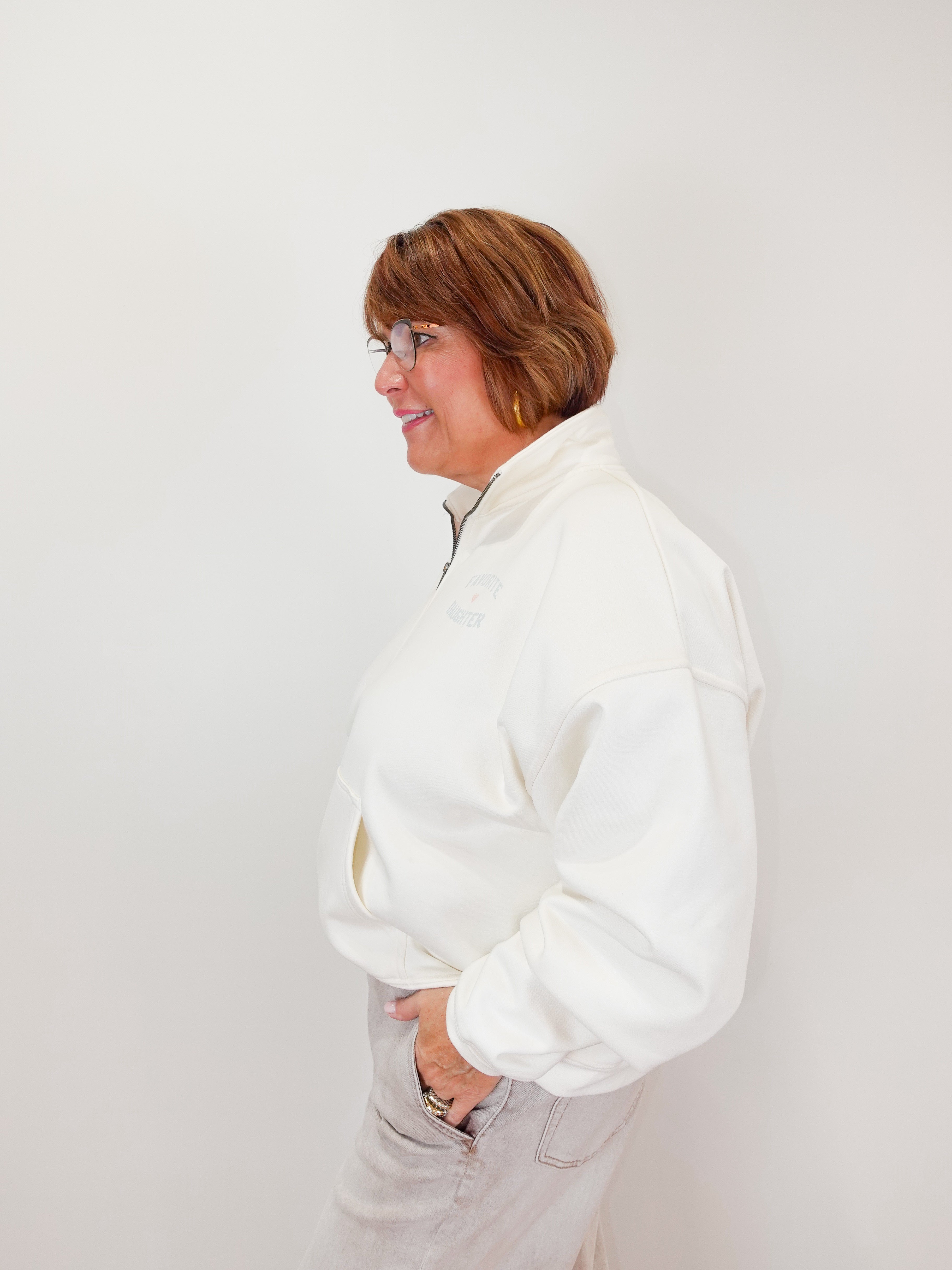 Person wearing a white jacket against a plain background