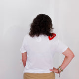 Person wearing a white t-shirt with a red heart design on the back, standing against a plain background.