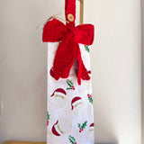 Gift bag with red knitted bow and patterned design on a white background