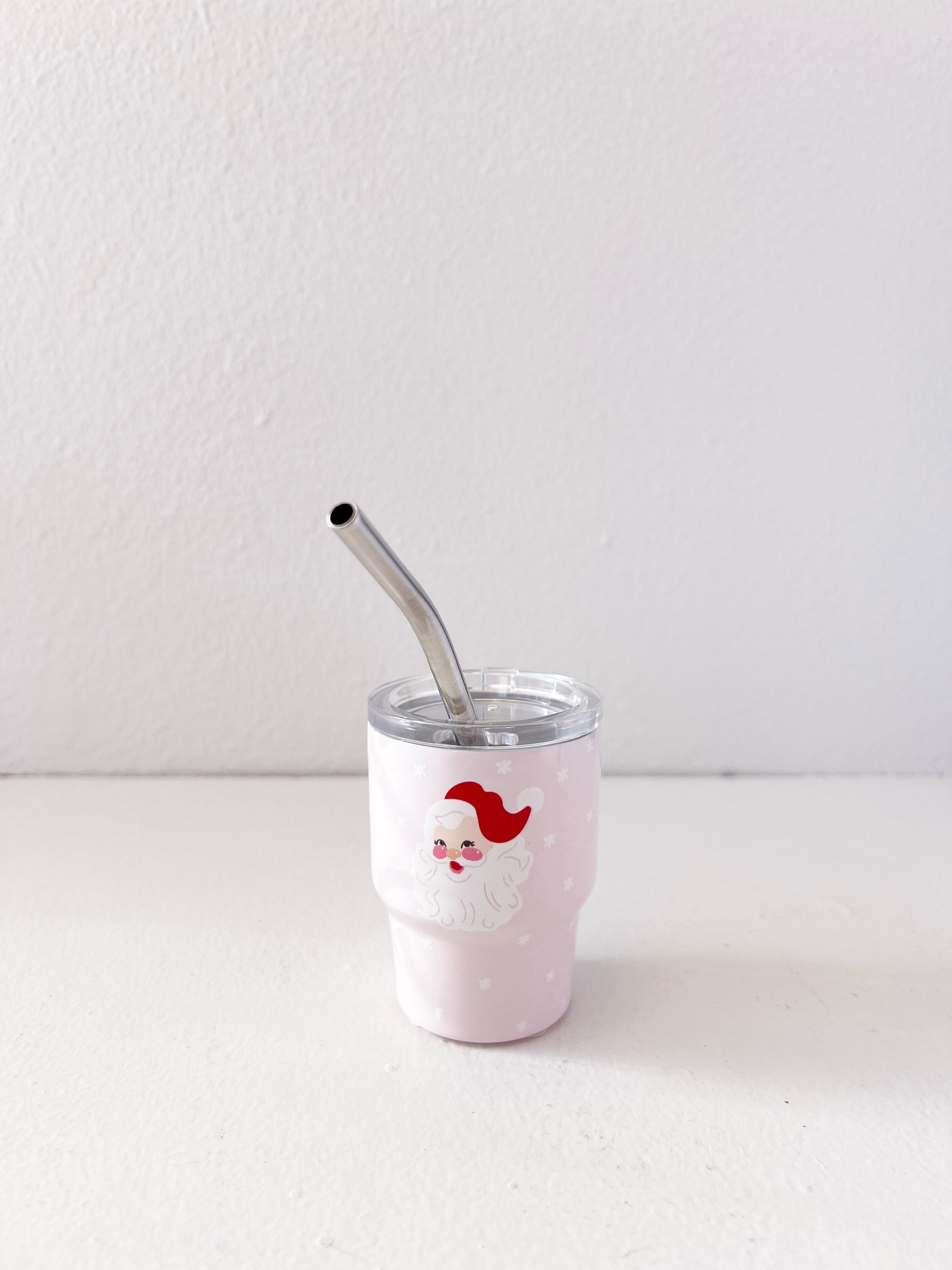 White tumbler with a red and white design and a metal straw on a light gray background