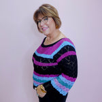 Person wearing a colorful striped sweater against a plain background