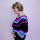 Person wearing a colorful striped sweater against a plain background