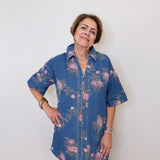 Woman wearing a blue floral dress against a white wall