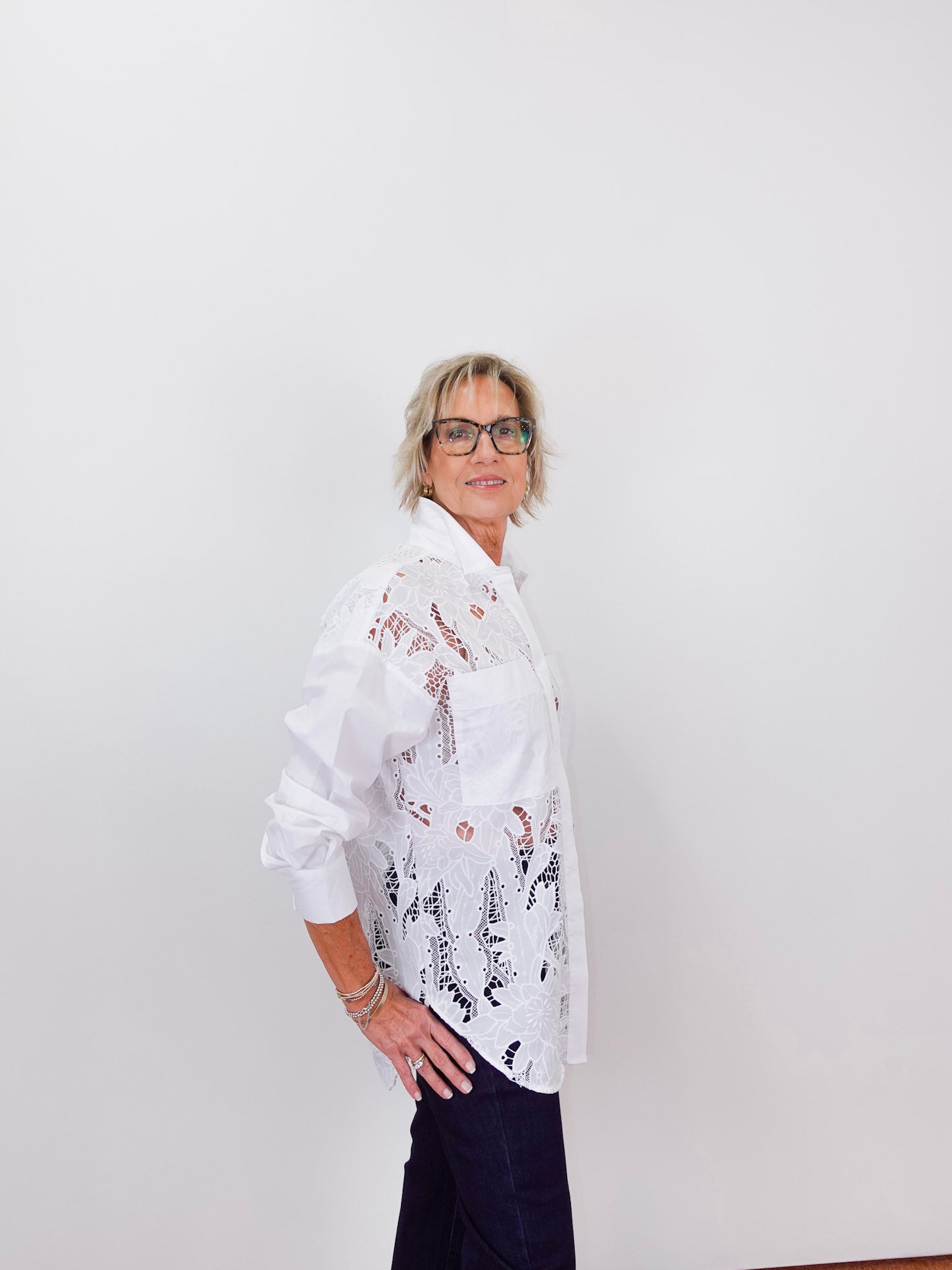 Person wearing a white floral blouse against a plain background
