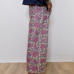Person wearing a patterned skirt with a plain background