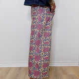 Person wearing a patterned skirt with a plain background