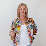 Woman wearing a colorful floral jacket against a white background