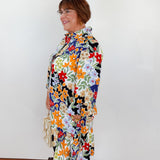 Woman wearing a colorful floral dress against a white background