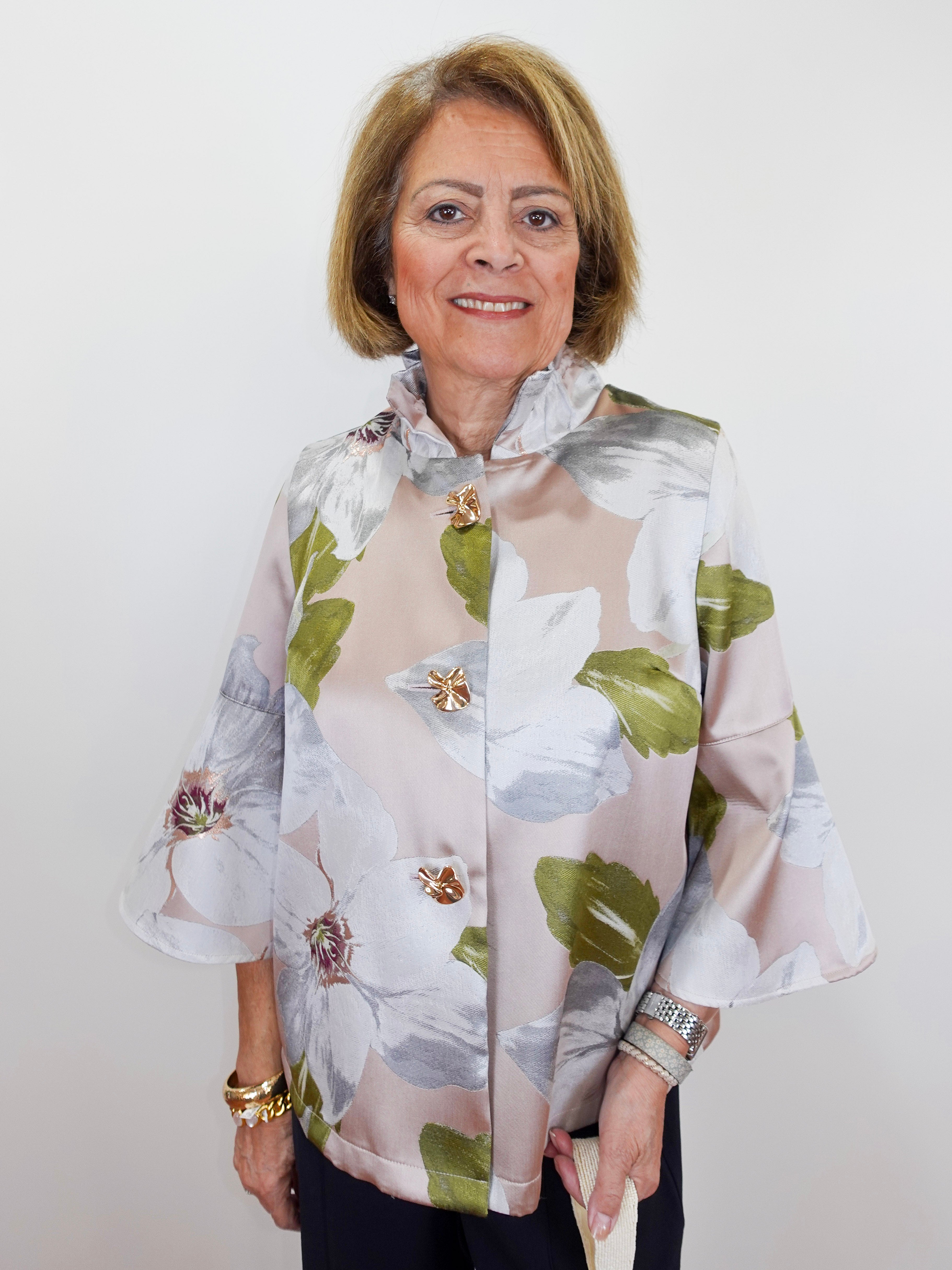 Woman wearing a floral blouse with a plain background