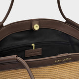 Brown handbag with visible brand name on a light gray background