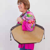 Person holding a large woven bag against a white background