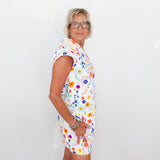 Woman wearing a colorful floral dress against a white background