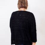 Person wearing a black cardigan against a white background