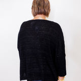 Person wearing a black cardigan against a white background