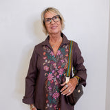 Woman wearing a patterned blouse with a plain background