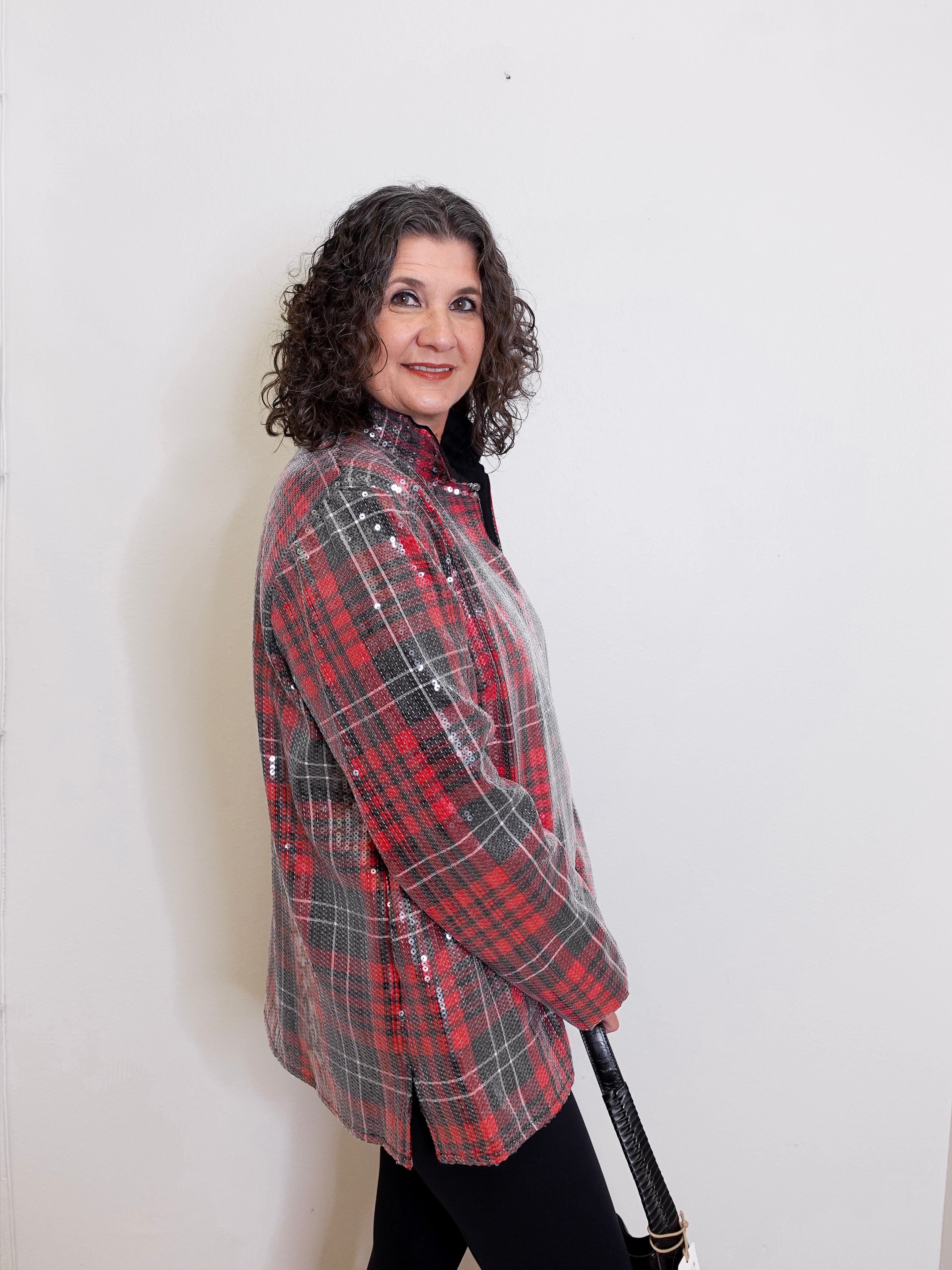 Woman wearing a red and gray plaid shirt against a white background