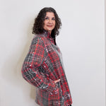 Woman wearing a red and black plaid shirt against a white background