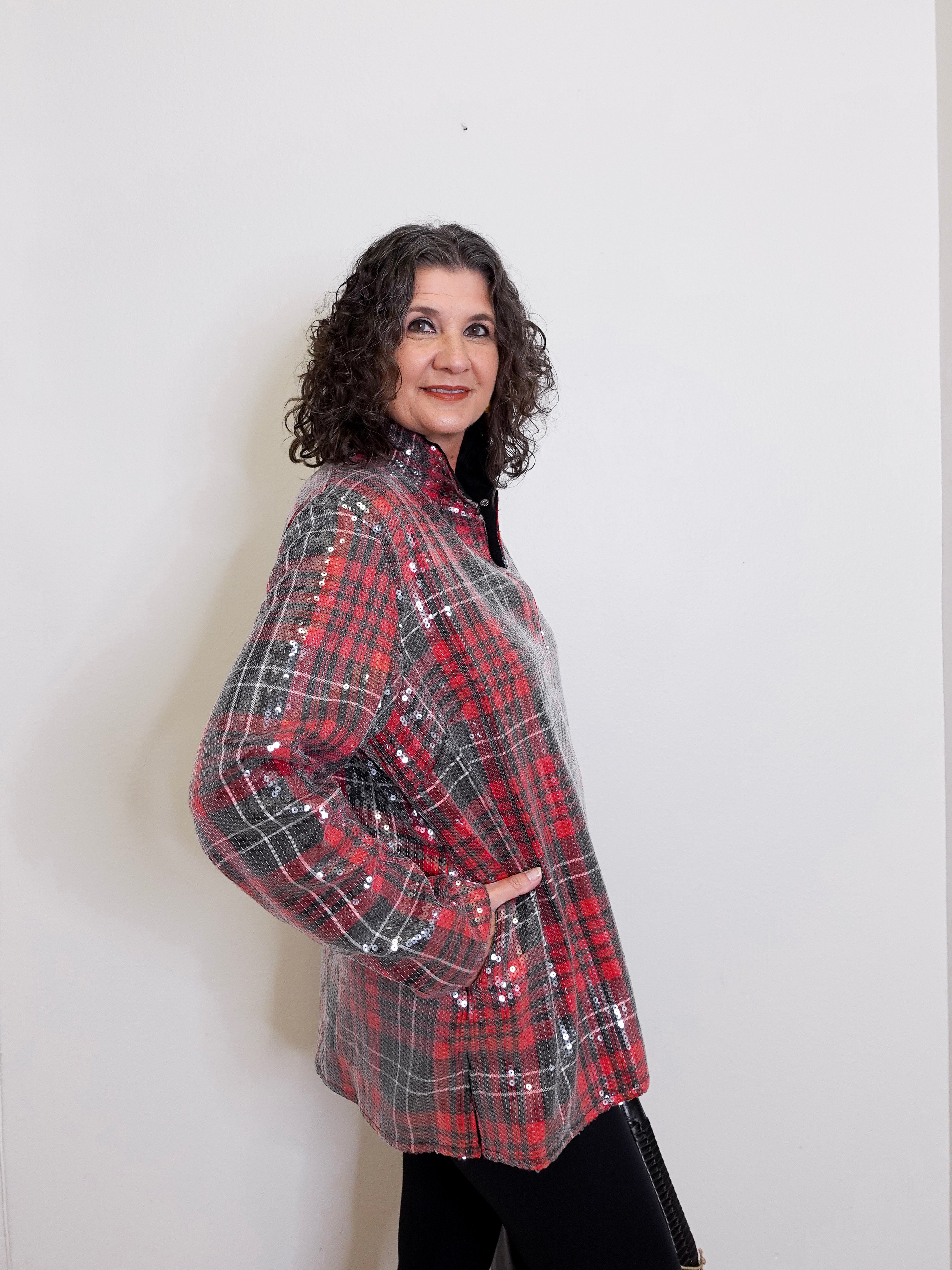 Woman wearing a red and black plaid shirt against a white background