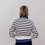 Person wearing a striped sweater with a plain background