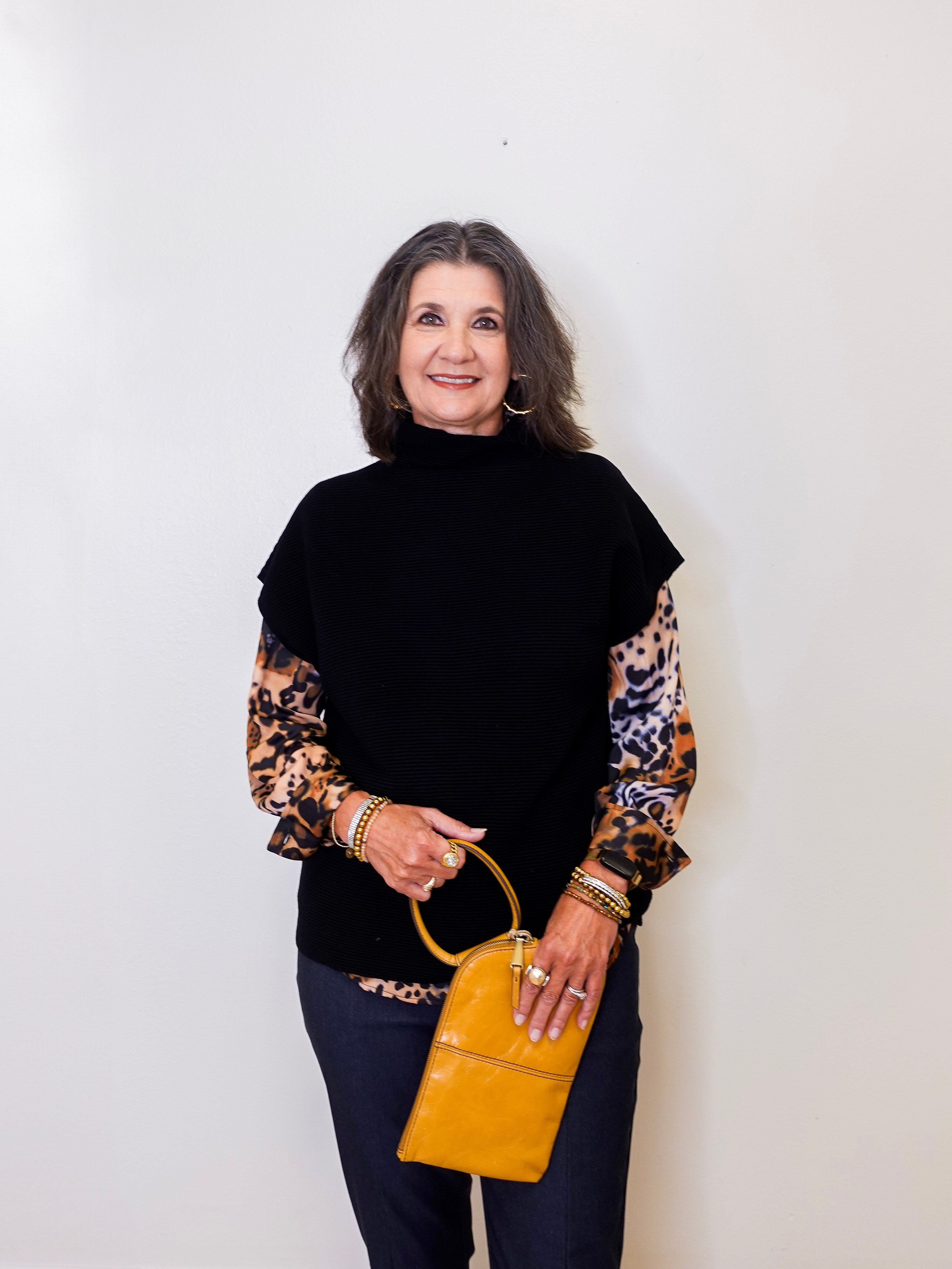 Woman holding a yellow handbag against a white background