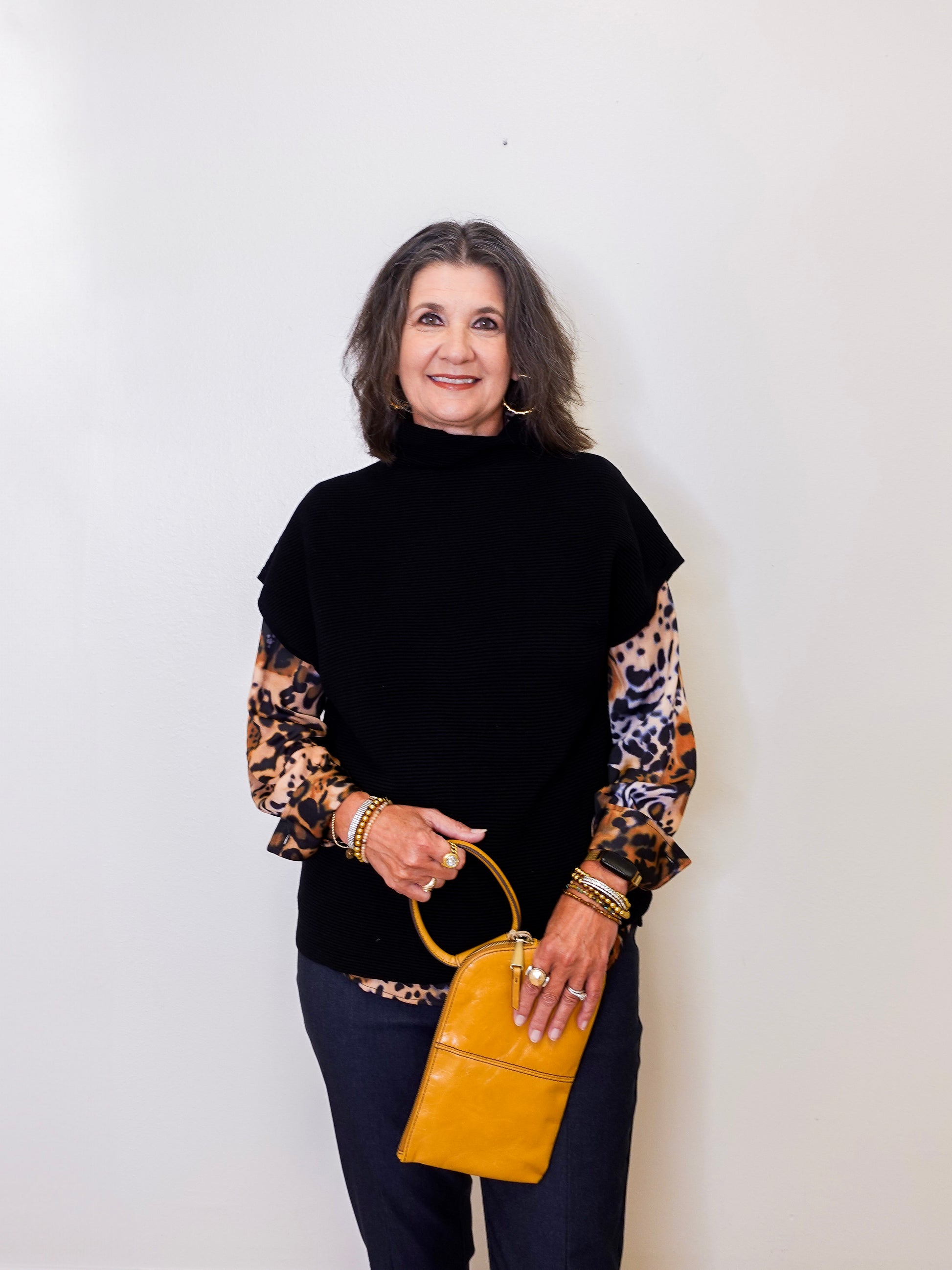 Woman holding a yellow handbag against a white background