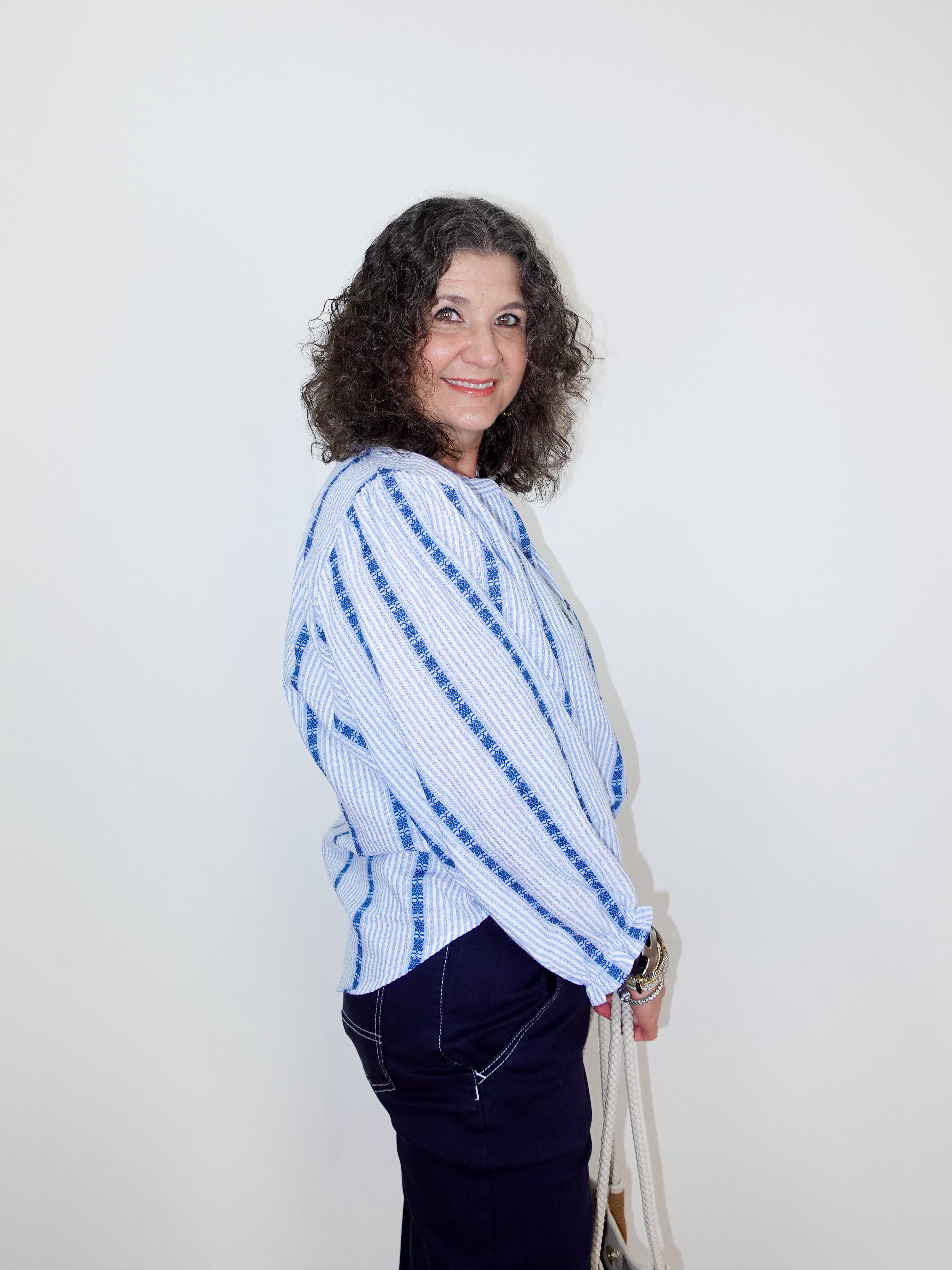 Woman wearing a blue and white tie-dye sweater against a plain background