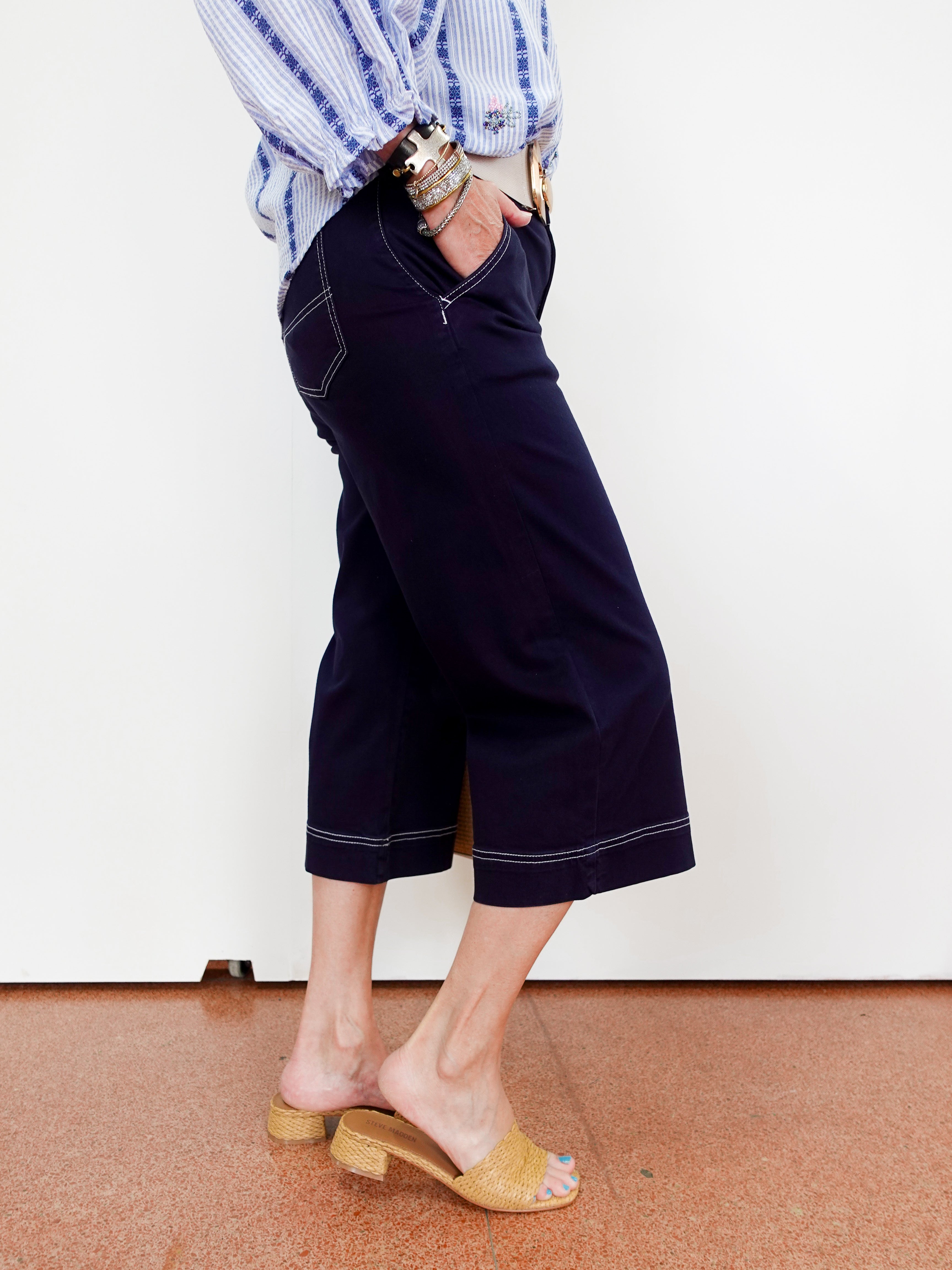 Person wearing navy blue shorts with a white background