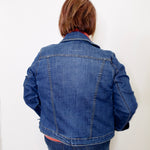 Person wearing a blue denim jacket against a white background