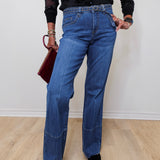 A woman modeling French dressing jeans the olivia bootleg jean against a white wall. 