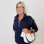 Woman wearing a navy blue pullover with a white background