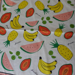 Fabric with colorful fruit pattern on a wooden surface